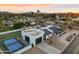 Aerial perspective of a house with a basketball court, putting green, and mature trees at 6601 E Hearn Rd, Scottsdale, AZ 85254