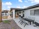 A covered patio with travertine flooring, a white exterior, and outdoor furniture at 6601 E Hearn Rd, Scottsdale, AZ 85254