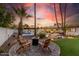 Backyard seating area with a firepit and four chairs overlooking a pool and lush landscaping at 6601 E Hearn Rd, Scottsdale, AZ 85254