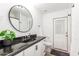 Bathroom with modern fixtures, sleek vanity, round mirror, and tiled floors at 6601 E Hearn Rd, Scottsdale, AZ 85254