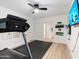 Bright exercise room featuring a ceiling fan, light wood floors, a treadmill, and wall-mounted yoga accessories at 6601 E Hearn Rd, Scottsdale, AZ 85254