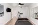 Home exercise room featuring hard wood floors, a wall mounted television, and a modern treadmill at 6601 E Hearn Rd, Scottsdale, AZ 85254