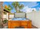 Hot tub with open cover, surrounded by greenery and fence at 6601 E Hearn Rd, Scottsdale, AZ 85254