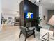 Modern living room featuring a fireplace, wood accent wall, light wood floors, and a view into the game room at 6601 E Hearn Rd, Scottsdale, AZ 85254