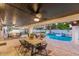 Covered patio area with dining table and lounge chairs near the pool at 6601 E Hearn Rd, Scottsdale, AZ 85254