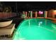 Sparkling pool at night with beautiful lighting and a serene waterfall feature at 6601 E Hearn Rd, Scottsdale, AZ 85254