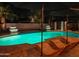 Stunning backyard pool area at night with luxurious lounge chairs and ambient lighting at 6601 E Hearn Rd, Scottsdale, AZ 85254