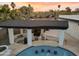 Aerial view of a backyard pool with a swim-up bar and outdoor kitchen area under sunset at 6601 E Hearn Rd, Scottsdale, AZ 85254