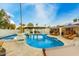 Sparkling pool with an attached spa, surrounded by lounge chairs, umbrellas, and lush landscaping at 6601 E Hearn Rd, Scottsdale, AZ 85254