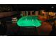 Backyard pool illuminated at night with a relaxing lounge chair in the foreground at 6601 E Hearn Rd, Scottsdale, AZ 85254