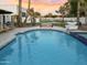 Swimming pool with unique design features, landscaping, and a putting green in the background at 6601 E Hearn Rd, Scottsdale, AZ 85254