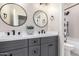 Modern bathroom featuring double sinks, round mirrors, and stylish gray cabinets at 662 W Raven Dr, Chandler, AZ 85286