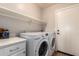 Functional laundry room with modern washer and dryer and shelf at 662 W Raven Dr, Chandler, AZ 85286