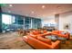 Inviting lounge area featuring an orange sectional sofa, tables, chairs, and expansive windows at 7180 E Kierland Blvd # 508, Scottsdale, AZ 85254