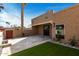 Well-kept backyard patio with fountain, decorative plants, and lush artificial turf at 7318 E Palo Verde Dr # 7, Scottsdale, AZ 85250