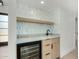 Stylish bar area featuring wine fridge, sleek cabinets, marble countertop, and decorative backsplash at 7318 E Palo Verde Dr # 7, Scottsdale, AZ 85250