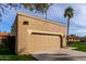 Tiled, two-car garage showcasing a well-kept lawn and desert landscaping at 7318 E Palo Verde Dr # 7, Scottsdale, AZ 85250