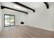 Bright living room featuring dark wood beams, fireplace, and sliding glass door to the backyard at 7318 E Palo Verde Dr # 7, Scottsdale, AZ 85250