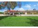 Green backyard featuring a small patio, view fence with manicured hedges, and mature shade trees at 8165 E Del Marino Dr, Scottsdale, AZ 85258