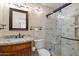 This modern bathroom features a granite vanity, water closet and an updated glass enclosed shower and stylish finishes at 8165 E Del Marino Dr, Scottsdale, AZ 85258