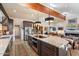 Spacious kitchen featuring a large island with granite countertop, stainless steel appliances, and a wooden beamed ceiling at 8165 E Del Marino Dr, Scottsdale, AZ 85258