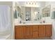 Bathroom featuring a double vanity, a mirrored wall, and classic fixtures at 951 N Poinciana Rd, Gilbert, AZ 85234