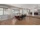 Dining area with a large window, hardwood floors, and seating for eight, open to the kitchen at 951 N Poinciana Rd, Gilbert, AZ 85234