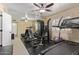 Spacious exercise room with rubber floor, large mirror, ceiling fan, and a variety of workout equipment at 951 N Poinciana Rd, Gilbert, AZ 85234