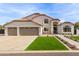 Charming two-story home featuring a three-car garage, manicured lawn, and beautiful desert landscaping at 951 N Poinciana Rd, Gilbert, AZ 85234