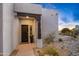 Inviting front door with dark wood accents, a welcome mat, and desert landscaping surroundings at 10029 E Calle De Las Brisas --, Scottsdale, AZ 85255
