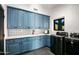 Well-appointed laundry room with blue cabinetry, stylish backsplash, and modern washer and dryer at 10029 E Calle De Las Brisas --, Scottsdale, AZ 85255