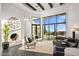 Bright living room boasts comfortable furniture, a grand fireplace, and large windows offering stunning desert views at 10029 E Calle De Las Brisas --, Scottsdale, AZ 85255