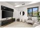 This living room features a large television, a neutral-colored chair, and a large window with a scenic view at 10029 E Calle De Las Brisas --, Scottsdale, AZ 85255