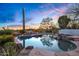 Beautiful pool with rock features and desert landscaping, reflecting the colorful sunset sky at 10029 E Calle De Las Brisas --, Scottsdale, AZ 85255
