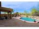 Serene backyard featuring a pool, covered patio, outdoor seating, desert landscaping, rock accents, and lush flowering plants at 10250 E Morning Star Dr, Scottsdale, AZ 85255