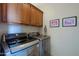 Well-equipped laundry room featuring a modern washer and dryer, plus upper cabinets for storage and fun cat artwork on the walls at 10250 E Morning Star Dr, Scottsdale, AZ 85255