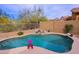 Inviting backyard pool area with rock waterfall feature, desert landscaping, and lush greenery, and a beautiful desert view at 10250 E Morning Star Dr, Scottsdale, AZ 85255