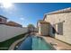 Backyard pool with clear blue water, surrounded by artificial turf, and view of covered outdoor seating area at 10623 W Alex Ave, Peoria, AZ 85382