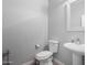 Small and efficient powder bathroom featuring a pedestal sink and toilet at 11851 W Alvarado Rd, Avondale, AZ 85392