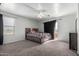 Cozy bedroom featuring a ceiling fan, access to a balcony, and a large window at 11851 W Alvarado Rd, Avondale, AZ 85392