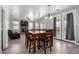 Bright dining room with a stone table, modern chandelier, and access to the backyard through glass doors at 11851 W Alvarado Rd, Avondale, AZ 85392