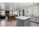 Modern kitchen with gray cabinets, stainless steel appliances, a marble island, and a view of the dining area at 11851 W Alvarado Rd, Avondale, AZ 85392