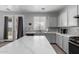 Bright kitchen featuring gray cabinets, a marble island, and stainless steel appliances at 11851 W Alvarado Rd, Avondale, AZ 85392