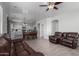 Spacious living room featuring tile floors, modern ceiling fan, and a comfortable leather sofa at 11851 W Alvarado Rd, Avondale, AZ 85392