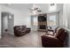 Cozy living room with stone fireplace, ceiling fan and leather furniture at 11851 W Alvarado Rd, Avondale, AZ 85392