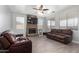 Cozy living room with stone fireplace, ceiling fan and leather furniture at 11851 W Alvarado Rd, Avondale, AZ 85392