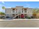 Inviting two-story condo building with stucco exterior, lush landscaping, and a charming staircase to upper units at 12050 N Panorama Dr # 107, Fountain Hills, AZ 85268