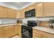 A view of a kitchen with wooden cabinets, black appliances, and granite countertops at 12050 N Panorama Dr # 107, Fountain Hills, AZ 85268