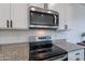 Modern kitchen features stainless steel appliances, granite countertops, and white cabinets at 1255 N Arizona Ave # 1246, Chandler, AZ 85225