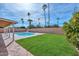 Inviting backyard with lush lawn and swimming pool, complete with palm trees and a privacy wall at 13014 N 23Rd Pl, Phoenix, AZ 85022